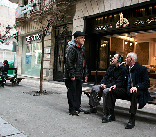 Tres personas con discapacidad intelectual charlando en un banco de Donostia.